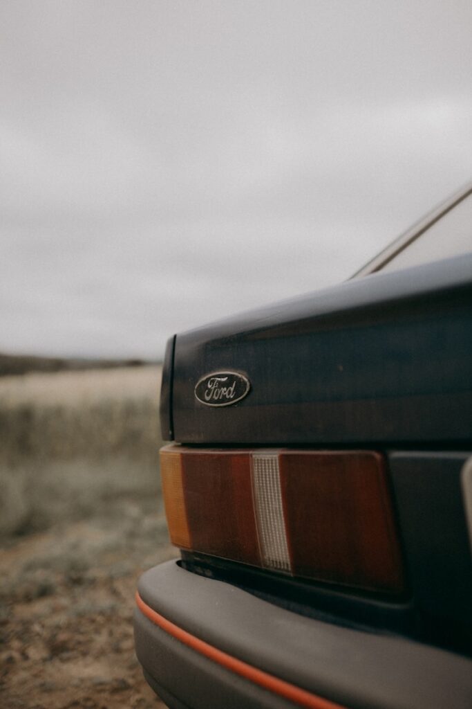 A close up of a car parked on a dirt road