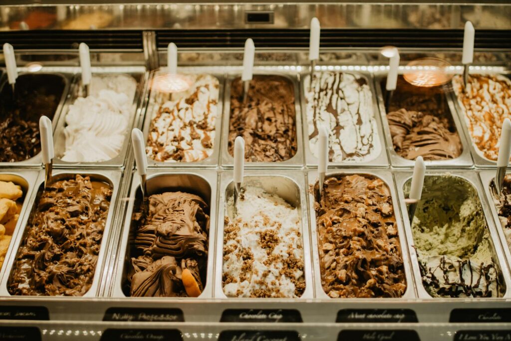 A close-up view of various gelato flavors in trays at a store.