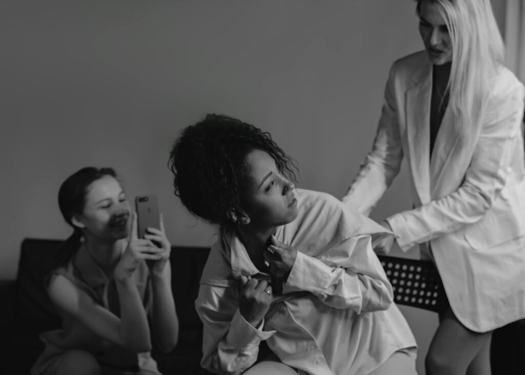 A dramatic black and white photograph capturing conflict and tension among diverse women.