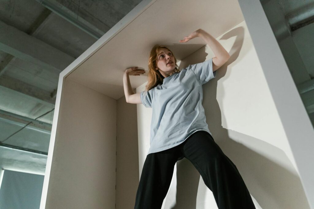 A woman appearing anxious inside a tight space, expressing feelings of claustrophobia and stress.
