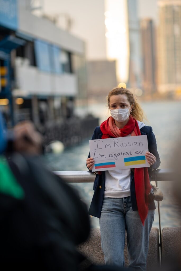 a woman wearing a face mask holding a sign