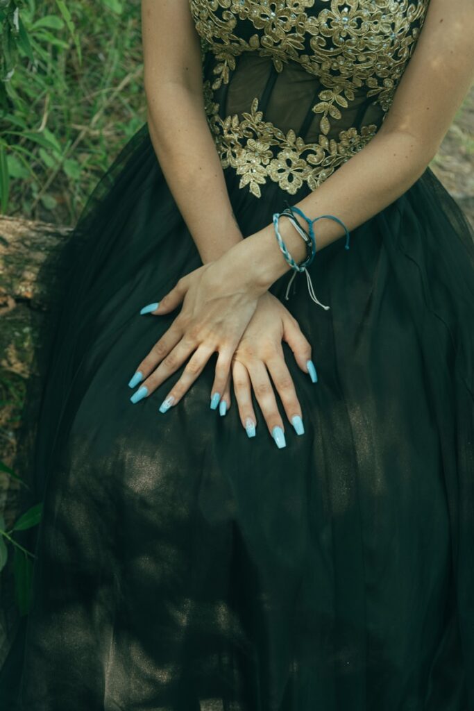 woman in black and gold floral dress with silver bracelet