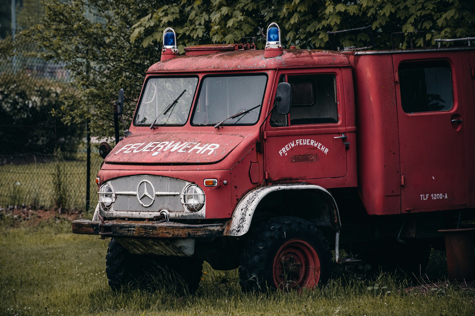 a red truck parked in a grassy field