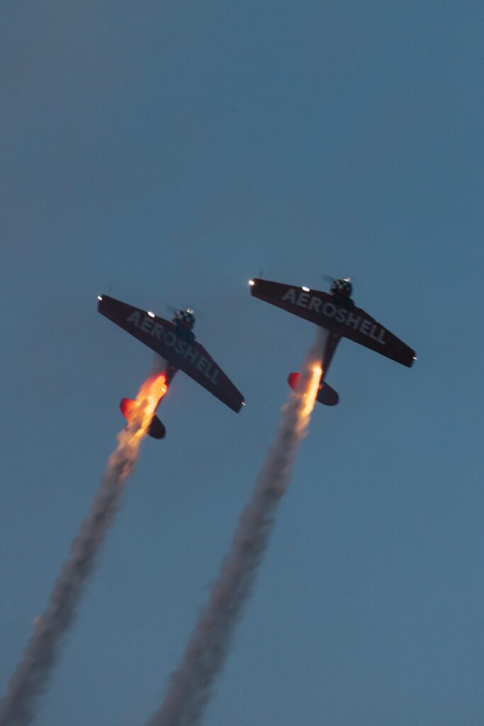 a couple of airplanes flying through a blue sky