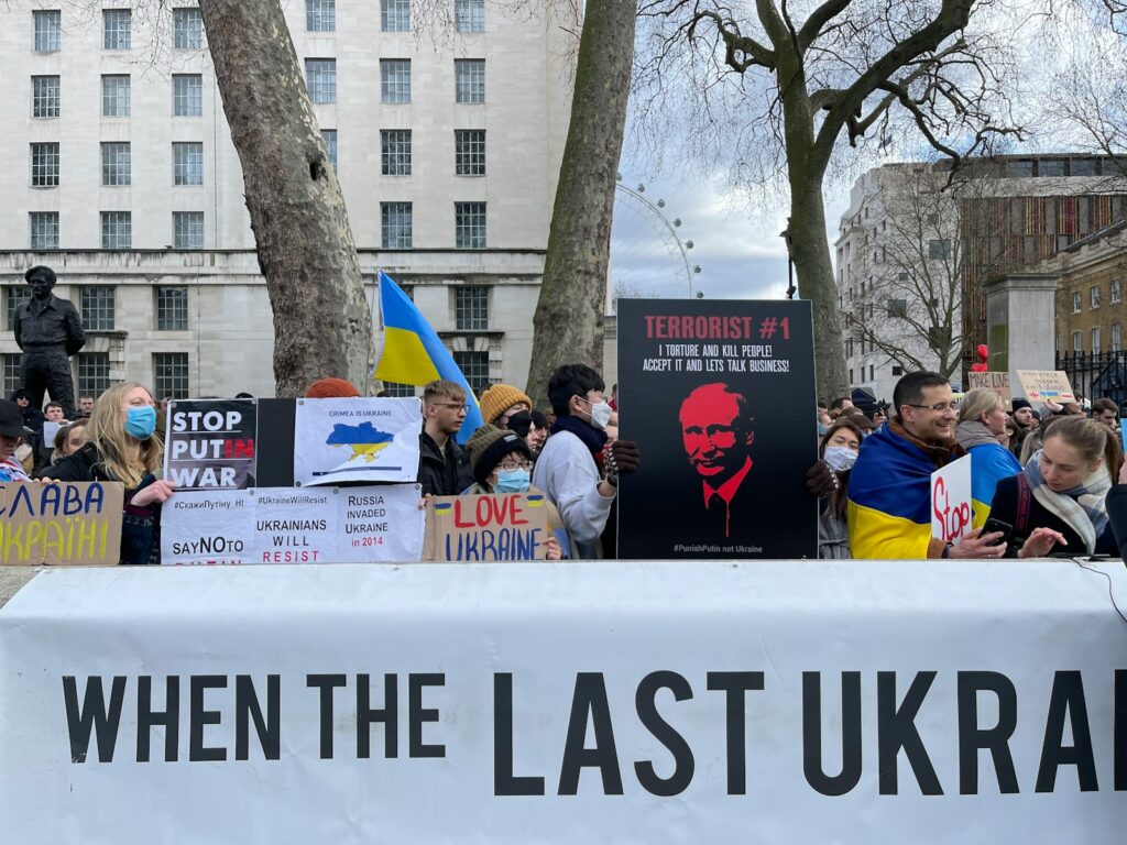a group of people holding signs in front of a building