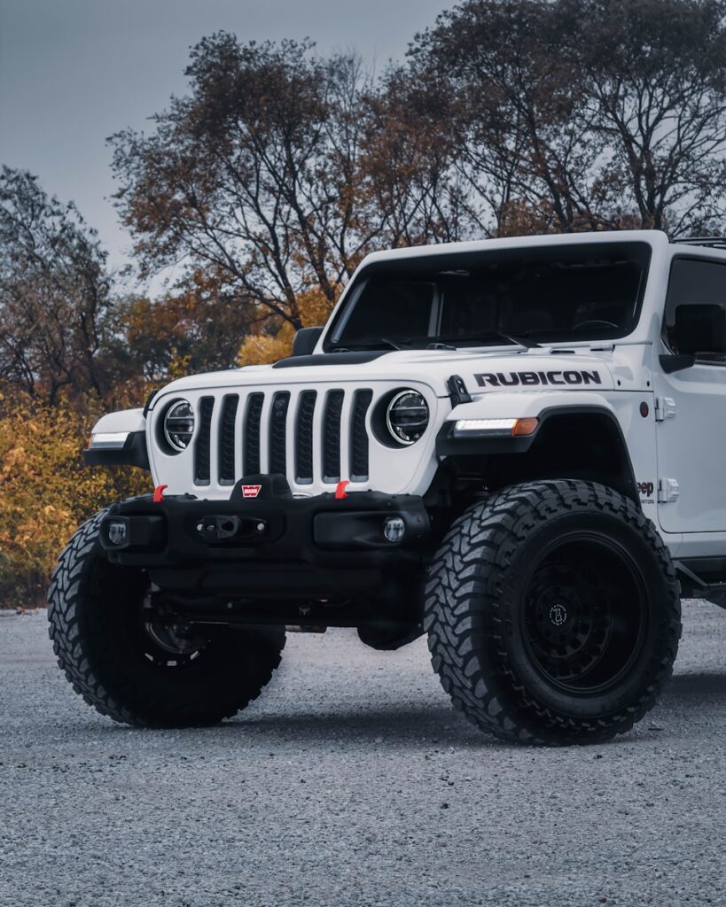 a white jeep is parked in a parking lot
