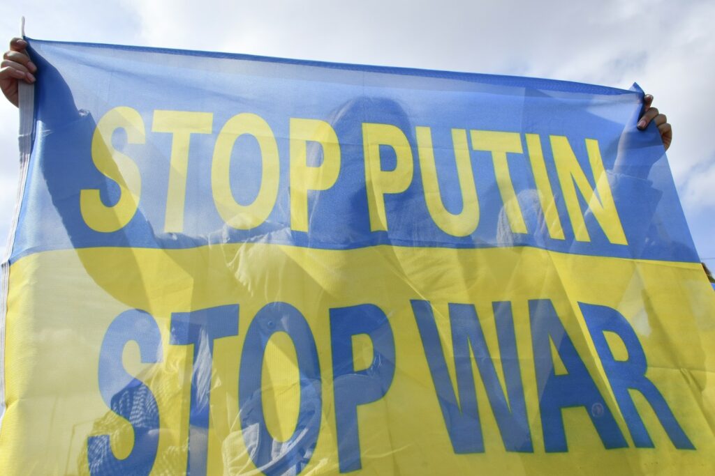 a person holding a sign that says stop putin't stop war
