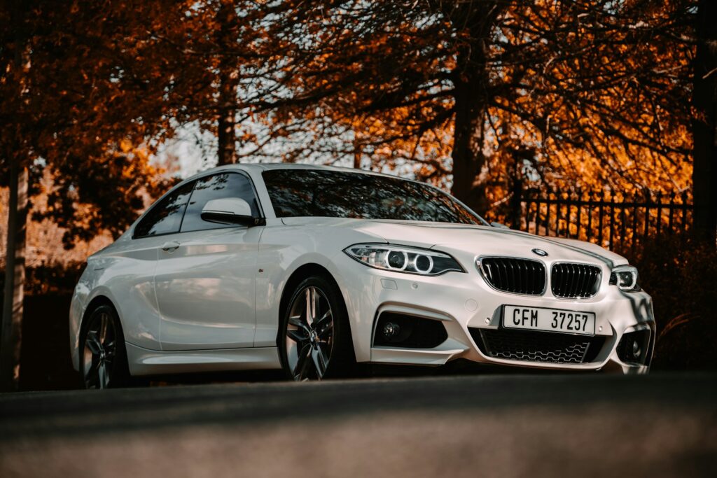 white bmw m 3 coupe parked near brown trees during daytime