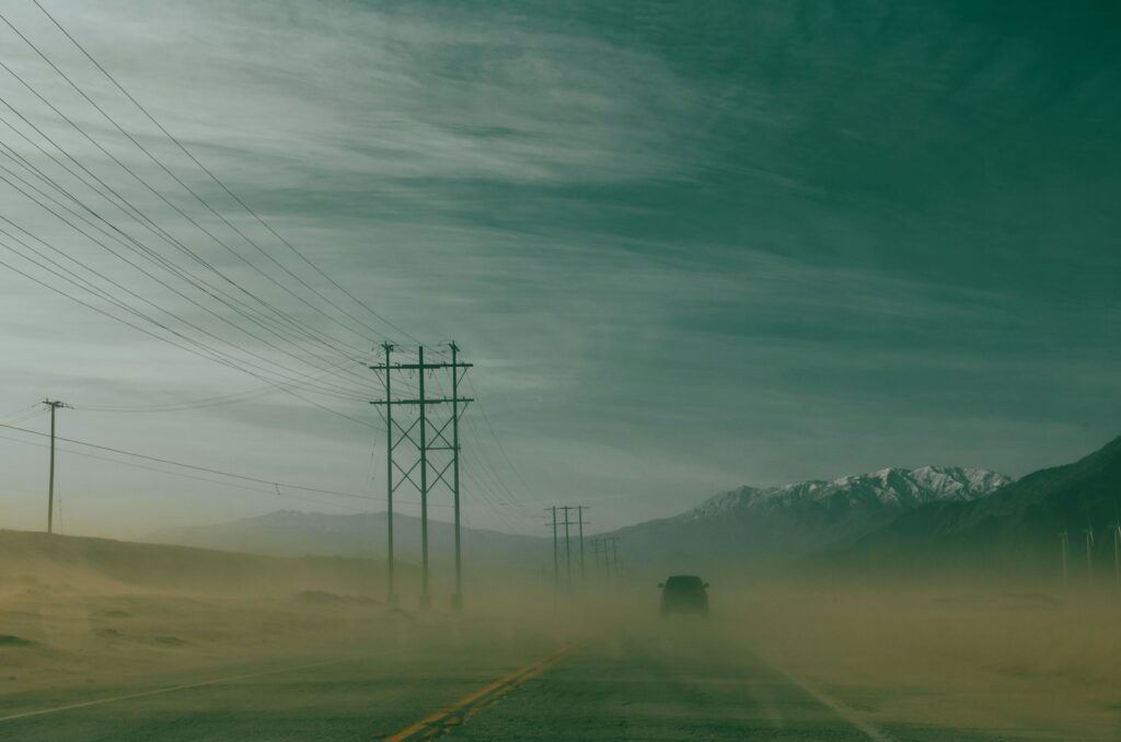 a car driving down a road in the middle of a desert