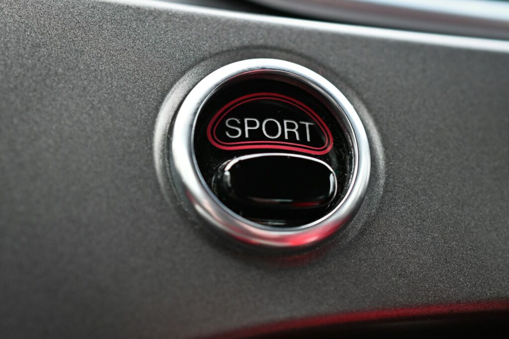 a close up of a sport button on a car