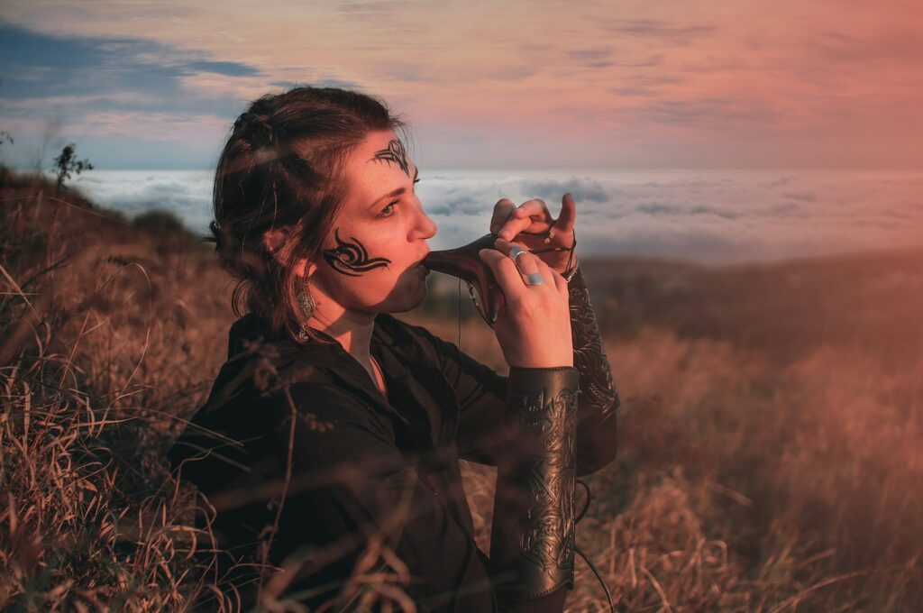 A woman standing in a field holding a snake