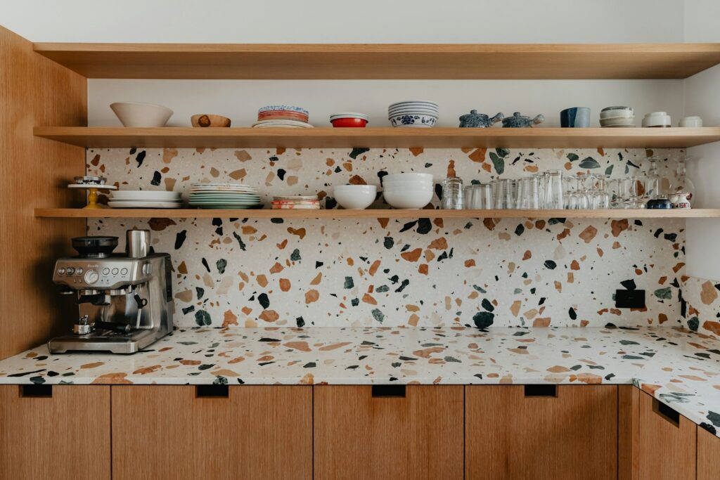 a kitchen counter with a coffee maker and cups on it