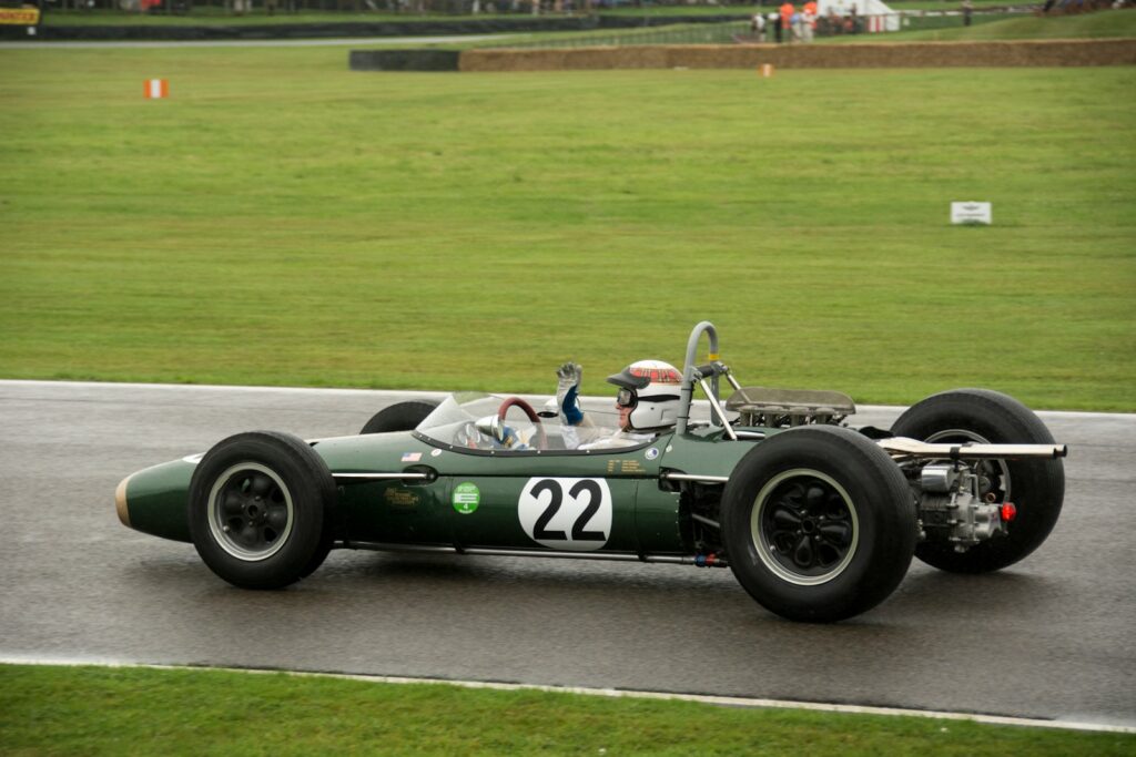 a green race car driving down a race track