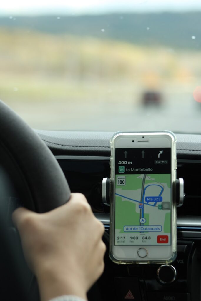 a person holding a cell phone while driving a car