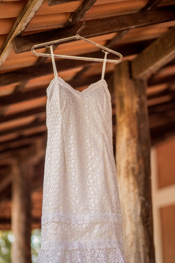 a white dress hanging on a wooden hanger