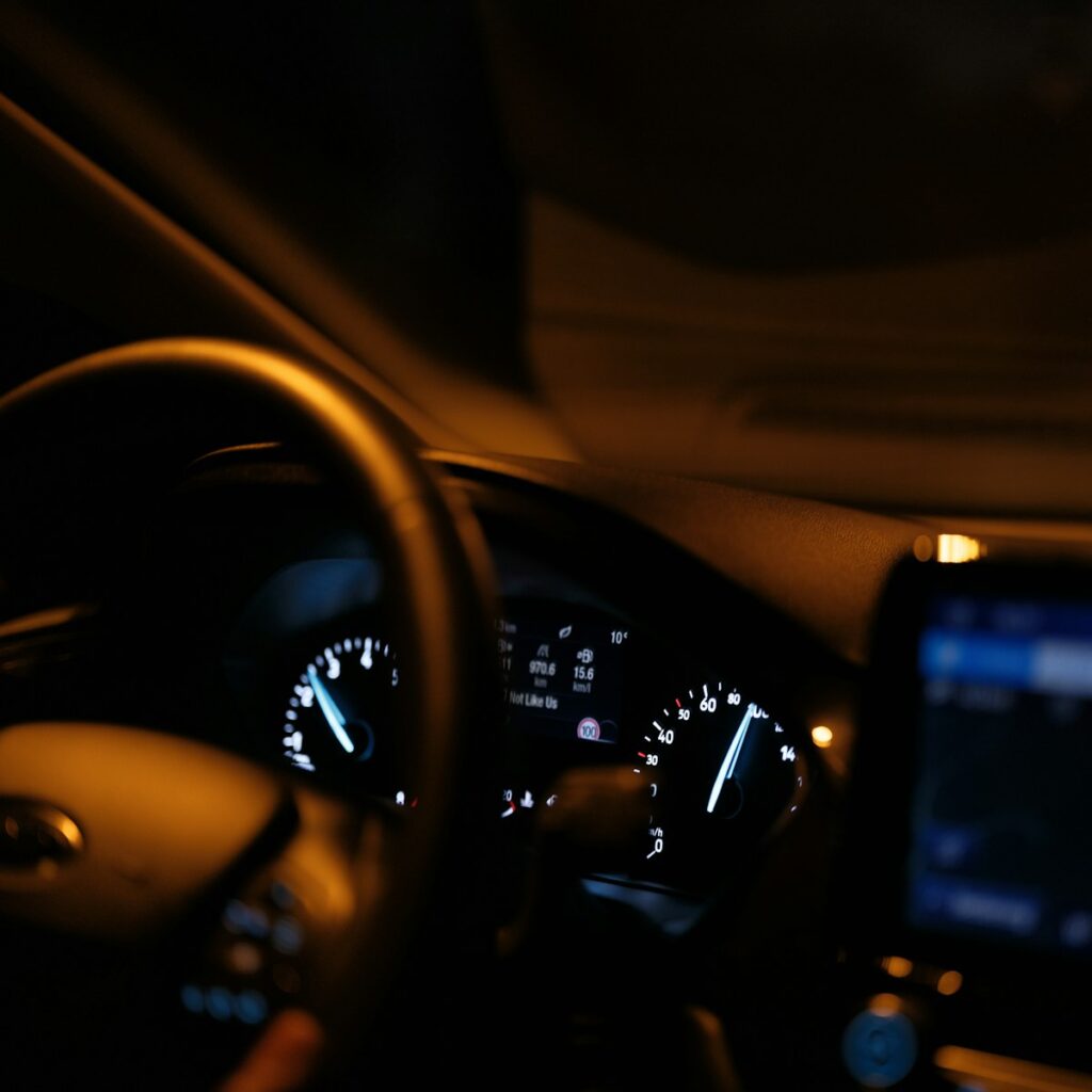 The dashboard of a car with a cell phone in it