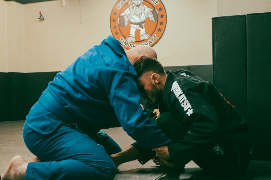 a man in a blue shirt and a man in a black jacket in a gym
