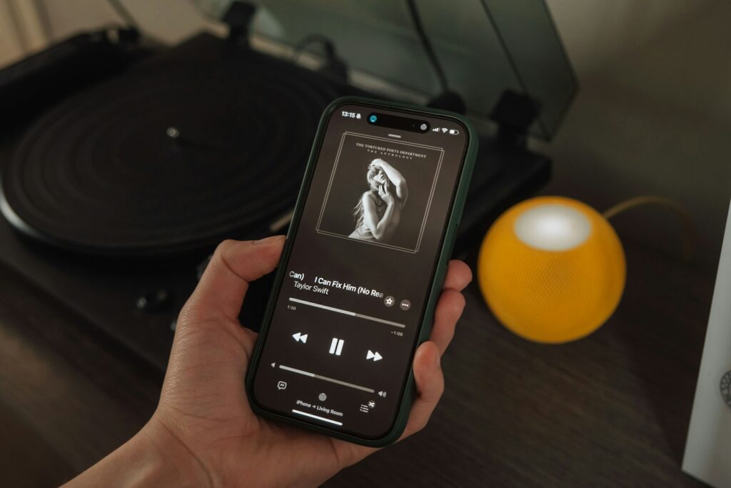 a person holding a cell phone in front of a record player