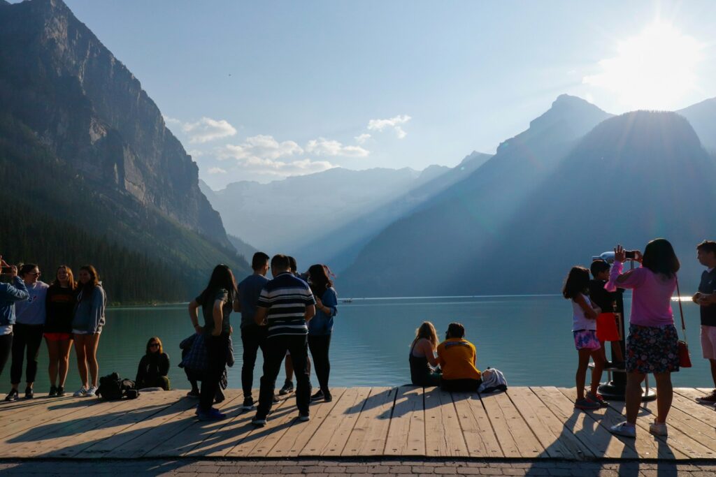 a group of people standing on a dock by a body of water
