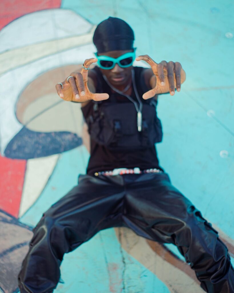 a man sitting on top of a skateboard in a skate park