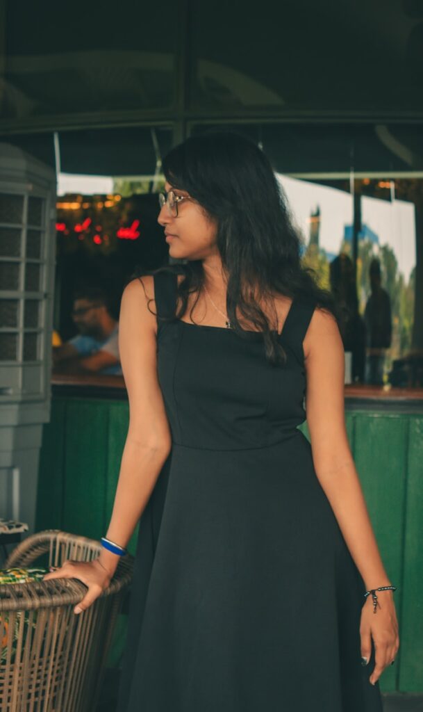 A woman in a black dress standing next to a basket