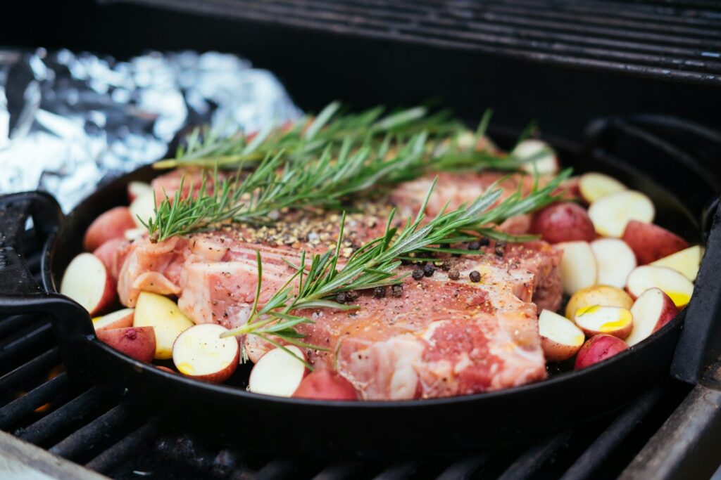 cooked meat with vegetables on black pan