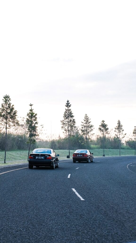 a couple of cars driving down a curvy road