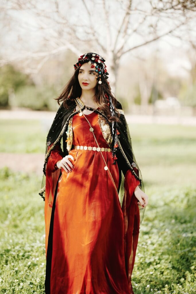 a woman in a red dress standing in a field