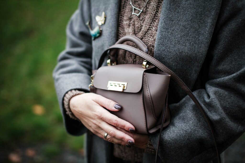 a woman holding a brown purse in her hands