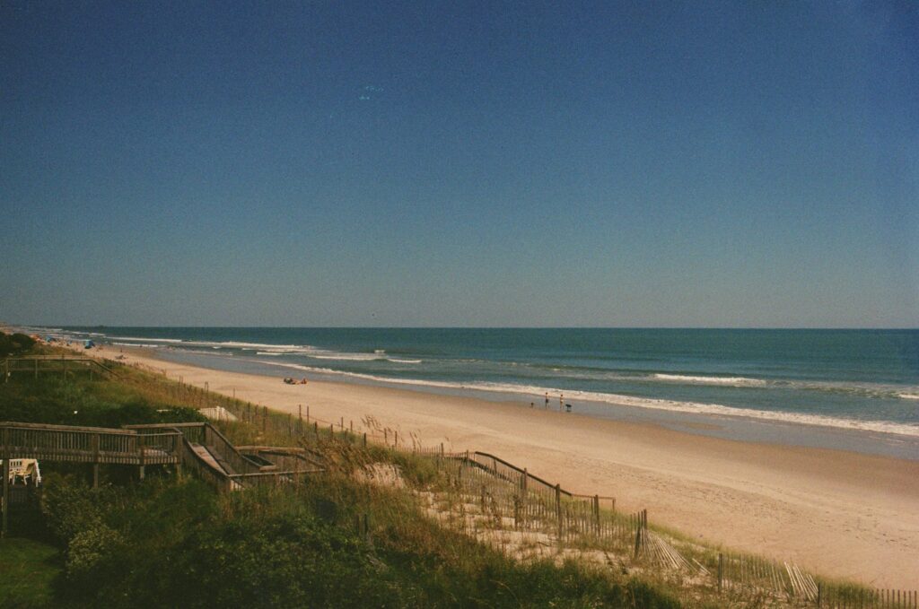 a view of a beach and ocean from the top of a hill
