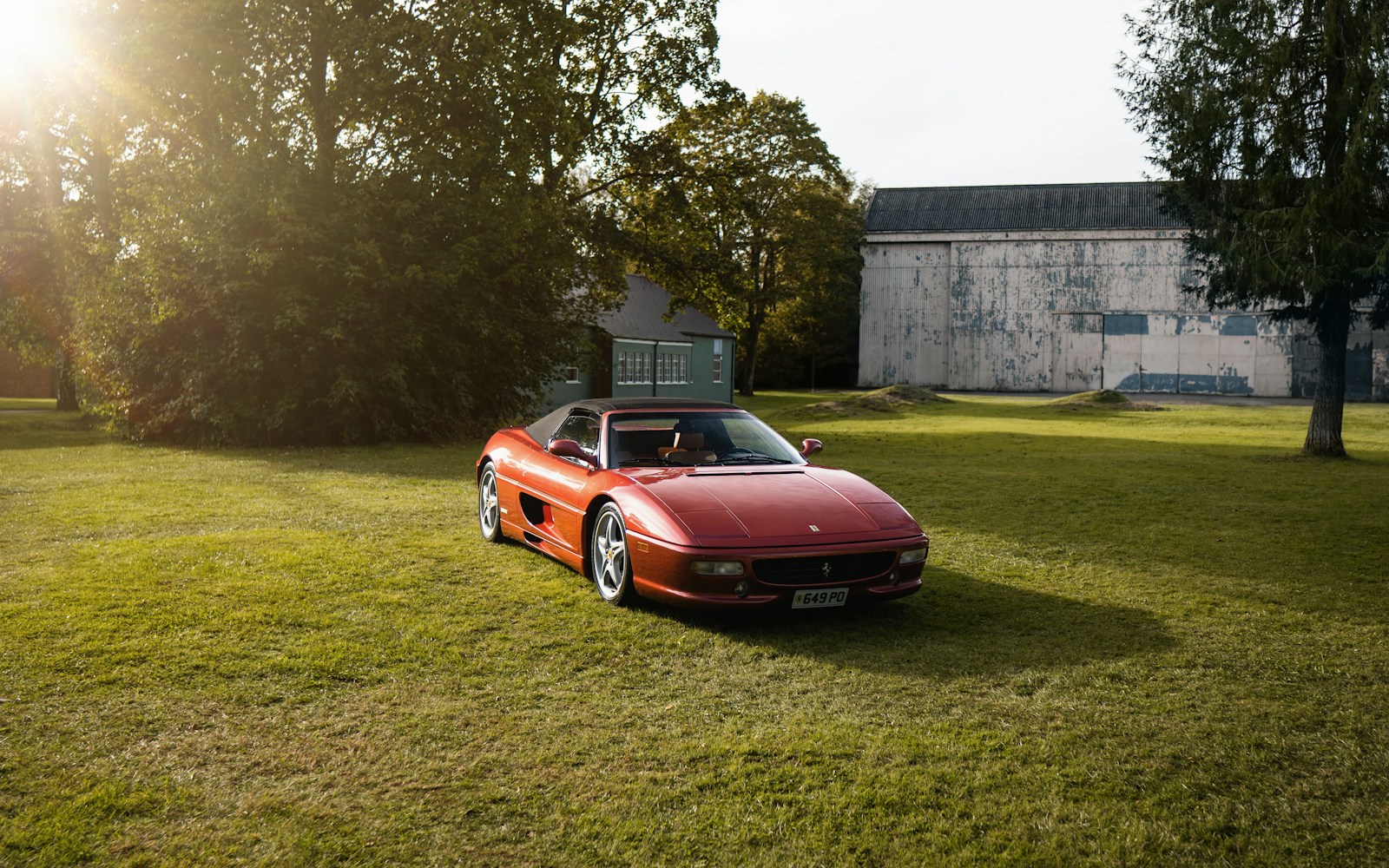 A red sports car parked in the grass