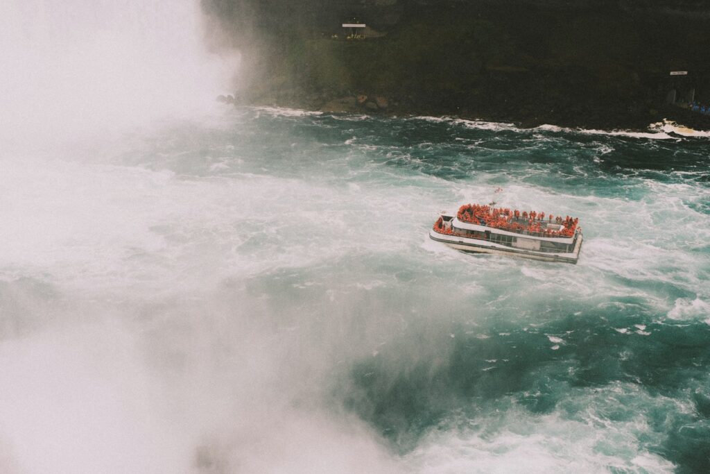 a boat in the water near a waterfall