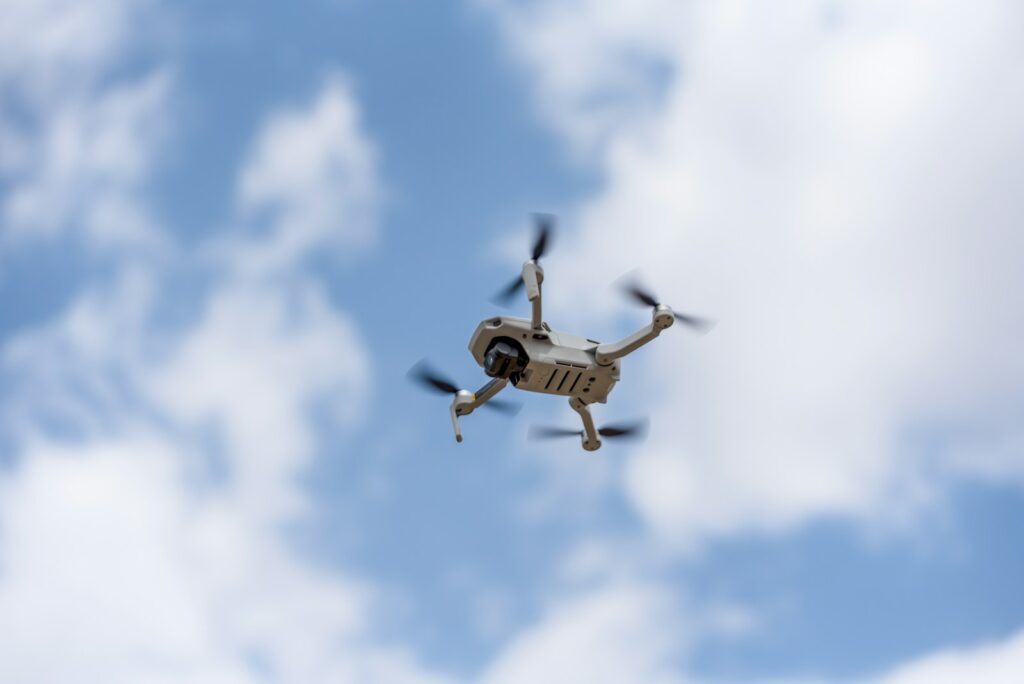 white drone flying in the sky during daytime