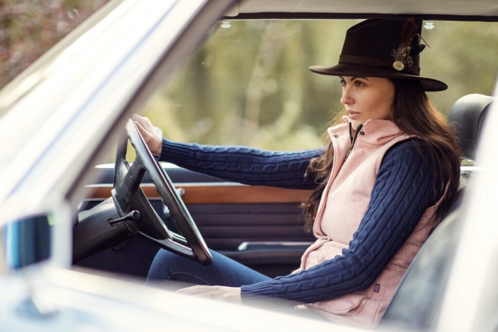 a woman wearing a hat sitting in a car