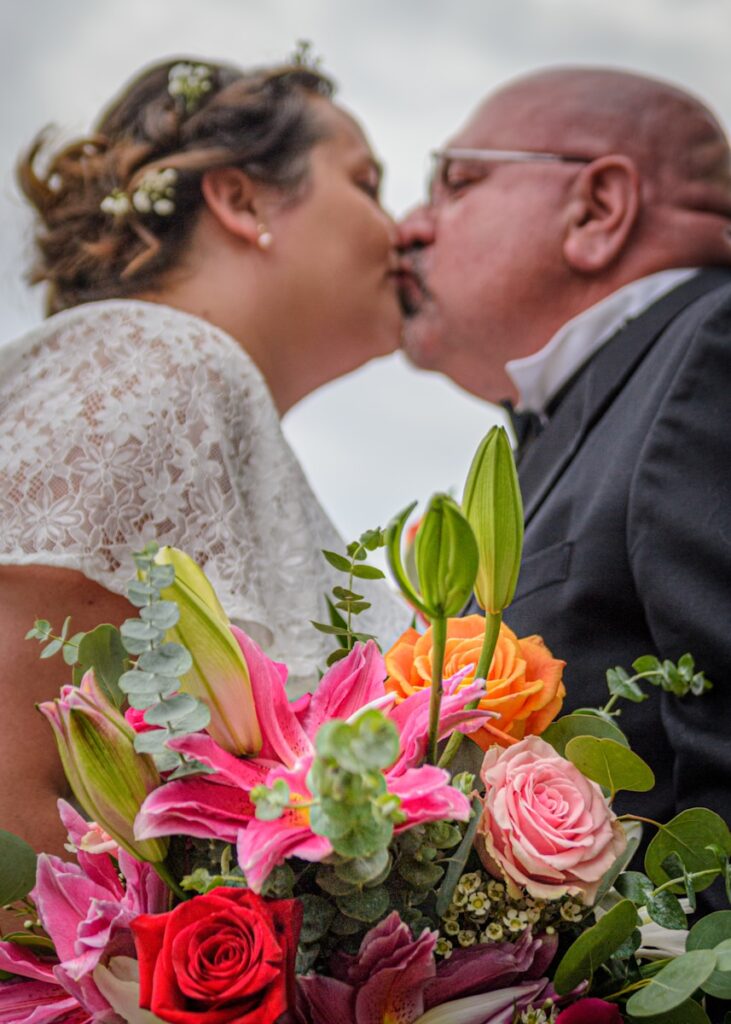 woman in white floral wedding dress holding bouquet of flowers