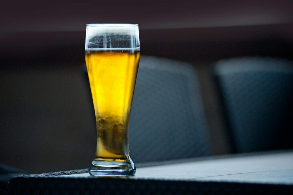 Macro shot of a cold beer in a tall glass on a table, perfect for refreshing moments.