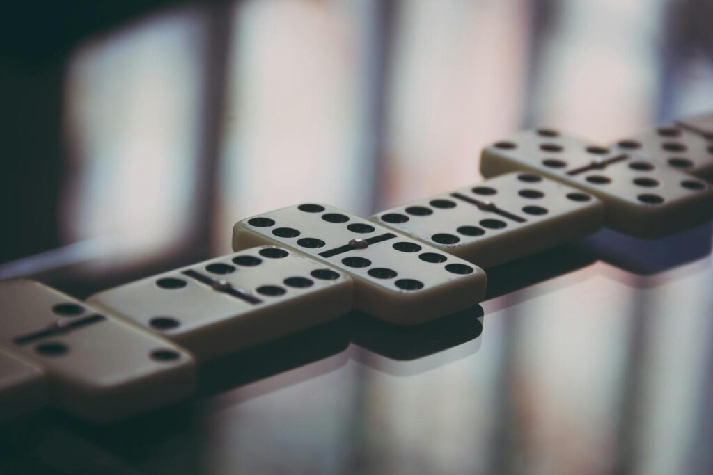 Artistic close-up of domino pieces on glass, highlighting the strategic game setup.