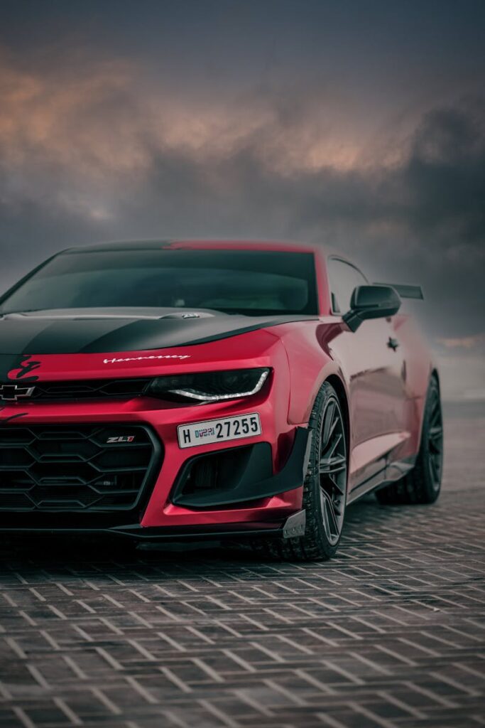 Red Chevrolet Camaro ZL1 parked with a moody sky backdrop. Perfect for automotive enthusiasts.