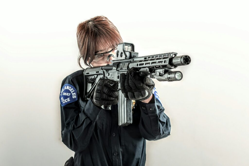 a woman holding a machine gun in her hands