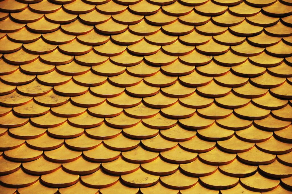 Close-up of a golden scaled roof pattern, ideal for design backgrounds or wallpapers.
