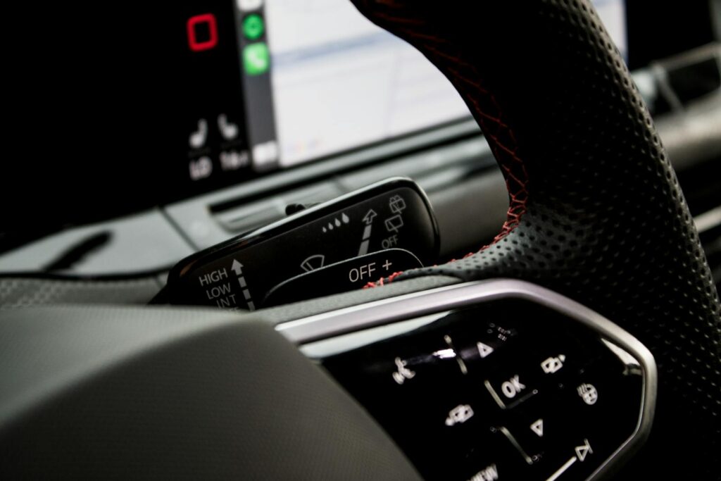 Detailed view of steering wheel controls in a modern car interior, emphasizing design and functionality.