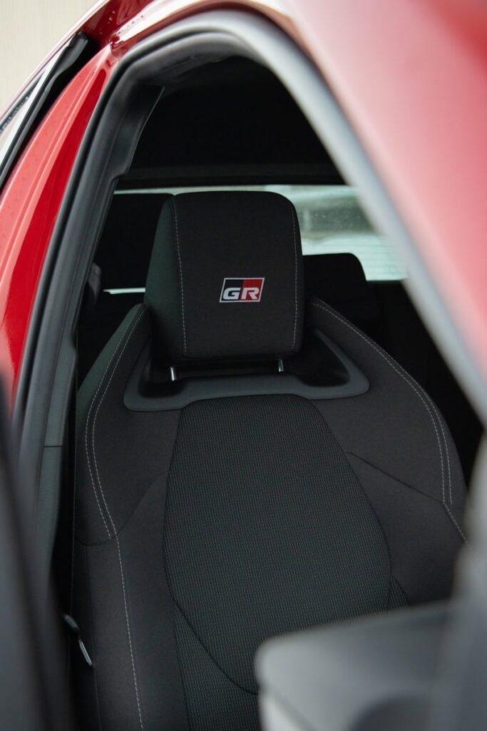 Close-up view of a black GR racing seat inside a vibrant red car.