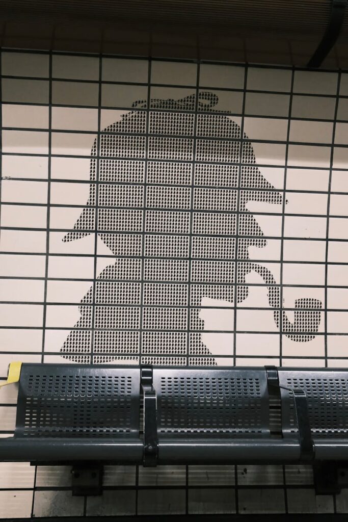 Silhouette of a detective with a pipe on a tiled subway wall.