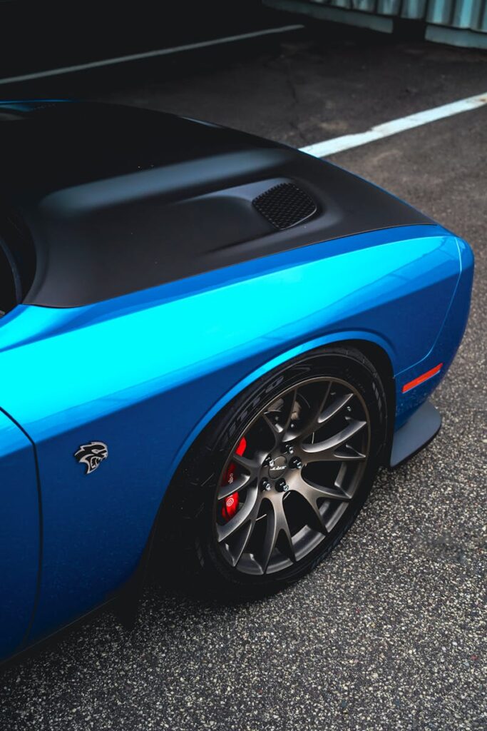 Close-up of a vibrant blue sports car with sleek alloy wheels and aerodynamic design.