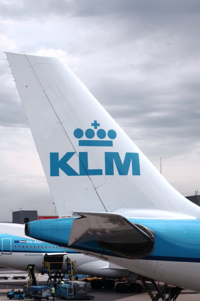 Close-up of KLM airplane tail on a cloudy day at the airport tarmac.