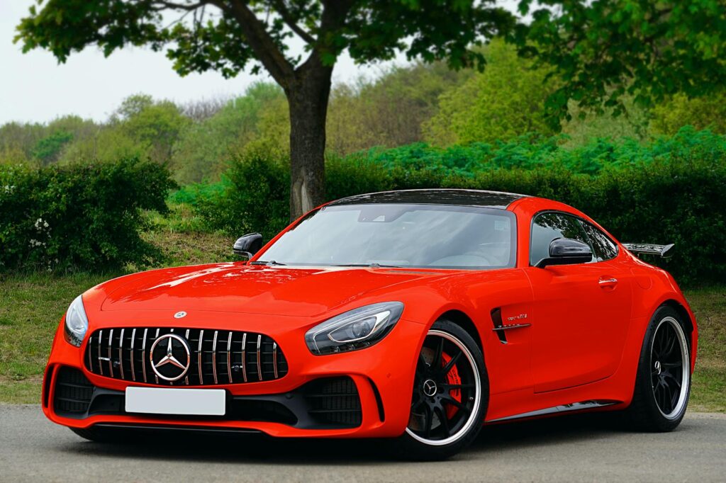 A stunning luxury red sports car parked on a scenic road in the UK.