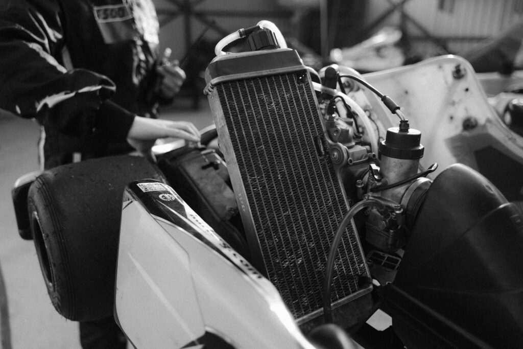 Monochrome image of a go-kart engine with radiator. Ideal for motorsport and technology themes.