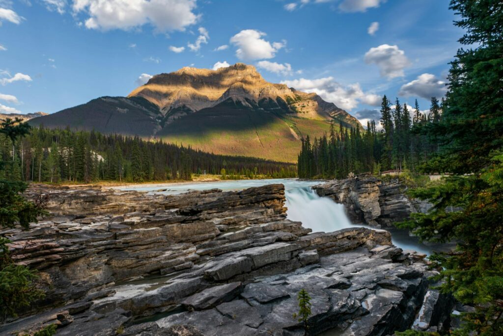 Stunning view of Athabasca Falls with the Rocky Mountains in Jasper National Park.