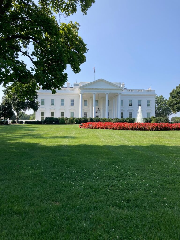 A large white building sitting on top of a lush green field