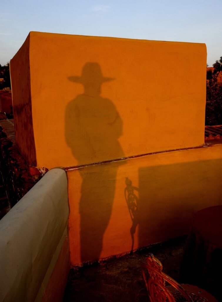 Mystic shadow of a cowboy casts on a terrace wall in Mexico at sunset, evoking Western themes.